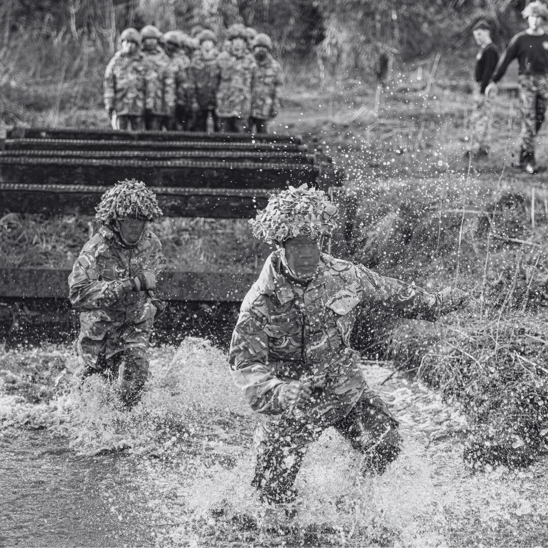 soldiers jumping into a water obstacle